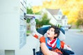 Disabled little boy in wheelchair getting mail from mailbox Royalty Free Stock Photo