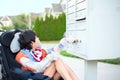 Disabled little boy in wheelchair getting mail from mailbox Royalty Free Stock Photo