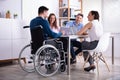 Disabled Manager Sitting With His Colleagues Royalty Free Stock Photo