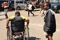 Disabled male on wheelchair with other male beggars at church yard begging for alms