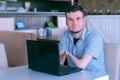 Disabled man with amputated two stump hands in cafe with laptop looks at camera. Royalty Free Stock Photo