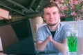 Disabled man amputated two stump hands in cafe looks at camera drinks cocktail. Royalty Free Stock Photo