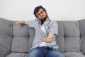 Disabled man with amputated two stump hands sitting on sofa looking at camera.