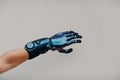 Disabled man with artificial prosthetic hand close up hand against gray background.