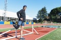 Disabled man athlete stretching with leg prosthesis. Paralympic Sport Concept.