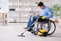 The disabled man cleaning home with vacuum cleaner