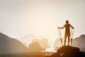 Disabled man with crutches on big rock stands like winner Royalty Free Stock Photo