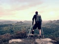 Disabled man on crutches on rock. Hurt knee in neoprene metal knee braces and man hold forearms crutches. Royalty Free Stock Photo