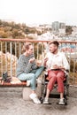 Disabled man frowning and eating fruit with his friend Royalty Free Stock Photo