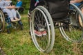 Disabled man resting in a campsite with friends. Wheelchair in the forest