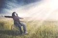 Disabled man sits on wheelchair at field