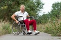 A disabled man sits in a wheelchair on the street. The concept of a wheelchair, disabled person, full life, paralyzed, disabled Royalty Free Stock Photo