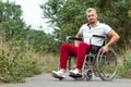 A disabled man sits in a wheelchair on the street. The concept of a wheelchair, disabled person, full life, paralyzed, disabled Royalty Free Stock Photo