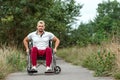 A disabled man sits in a wheelchair on the street. The concept of a wheelchair, disabled person, full life, paralyzed, disabled Royalty Free Stock Photo