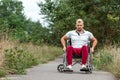 A disabled man sits in a wheelchair on the street. The concept of a wheelchair, disabled person, full life, paralyzed, disabled Royalty Free Stock Photo