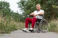 A disabled man sits in a wheelchair on the street. The concept of a wheelchair, disabled person, full life, paralyzed, disabled Royalty Free Stock Photo