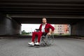 A disabled man sits in a wheelchair on the street. The concept of a wheelchair, disabled person, full life, paralyzed, disabled Royalty Free Stock Photo