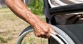 A disabled man is sitting in a wheelchair ,Holds his hands on the wheel. Handicap people Concept