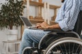 Disabled man sitting in a wheelchair and using laptop Royalty Free Stock Photo