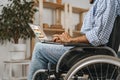 Disabled man sitting in a wheelchair and using laptop Royalty Free Stock Photo