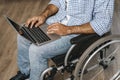 Disabled man sitting in a wheelchair and using laptop Royalty Free Stock Photo