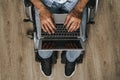 Disabled man sitting in a wheelchair and using laptop Royalty Free Stock Photo