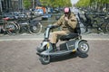 disabled man stunts on scoot mobile on bridge in centre on amsterdam Royalty Free Stock Photo