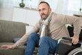 disabled man tries to sit on sofa Royalty Free Stock Photo