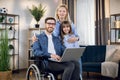 Disabled man using laptop while wife and daughter hugging Royalty Free Stock Photo