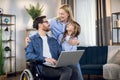 Disabled man using laptop while wife and daughter hugging Royalty Free Stock Photo