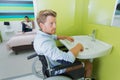 Disabled man using sink in hotel room