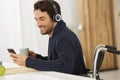 disabled man wearing headphones and using smartphone Royalty Free Stock Photo