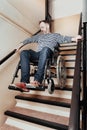 Disabled man living in city apartment house trying to ride downstairs