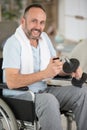 disabled man in wheelchair adds weight to dumbbell