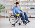 Disabled man on wheelchair cleaning home