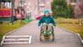 Disabled man in wheelchair going down the ramp outdoors Royalty Free Stock Photo