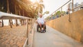 Disabled man in a wheelchair moves on a ramp to the beach. Royalty Free Stock Photo