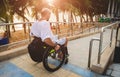 Disabled man in a wheelchair moves on a ramp to the beach. Royalty Free Stock Photo