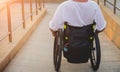 Disabled man in a wheelchair moves on a ramp to the beach. Royalty Free Stock Photo