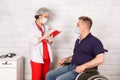 A disabled man in a wheelchair at the reception of a woman doctor Royalty Free Stock Photo