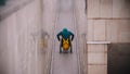 Disabled man in wheelchair wearing jacket and hat - going up the long ramp in the subway Royalty Free Stock Photo