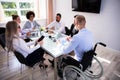 Disabled Manager Sitting With His Colleagues Royalty Free Stock Photo