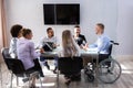 Disabled Manager Sitting With His Colleagues Royalty Free Stock Photo