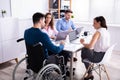 Disabled Manager Sitting With His Colleagues Royalty Free Stock Photo