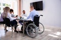 Disabled Manager Sitting With His Colleagues Royalty Free Stock Photo