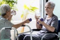 Disabled old elderly people in a wheelchair drinking beverages,dietary supplements,healthy senior woman holding glass of fresh Royalty Free Stock Photo