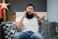 Disabled painful man with neck brace talking on phone at home. Man with spine trauma in neck brace cervical call Royalty Free Stock Photo