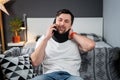 Disabled painful man with neck brace talking on phone at home. Man with spine trauma in neck brace cervical call Royalty Free Stock Photo