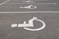 Disabled parking sign in a parking space. Symbol of a person in a wheelchair on the pavement, drawn by white paint Royalty Free Stock Photo
