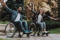 Disabled People on Wheelchairs Have Fun in Park. Royalty Free Stock Photo